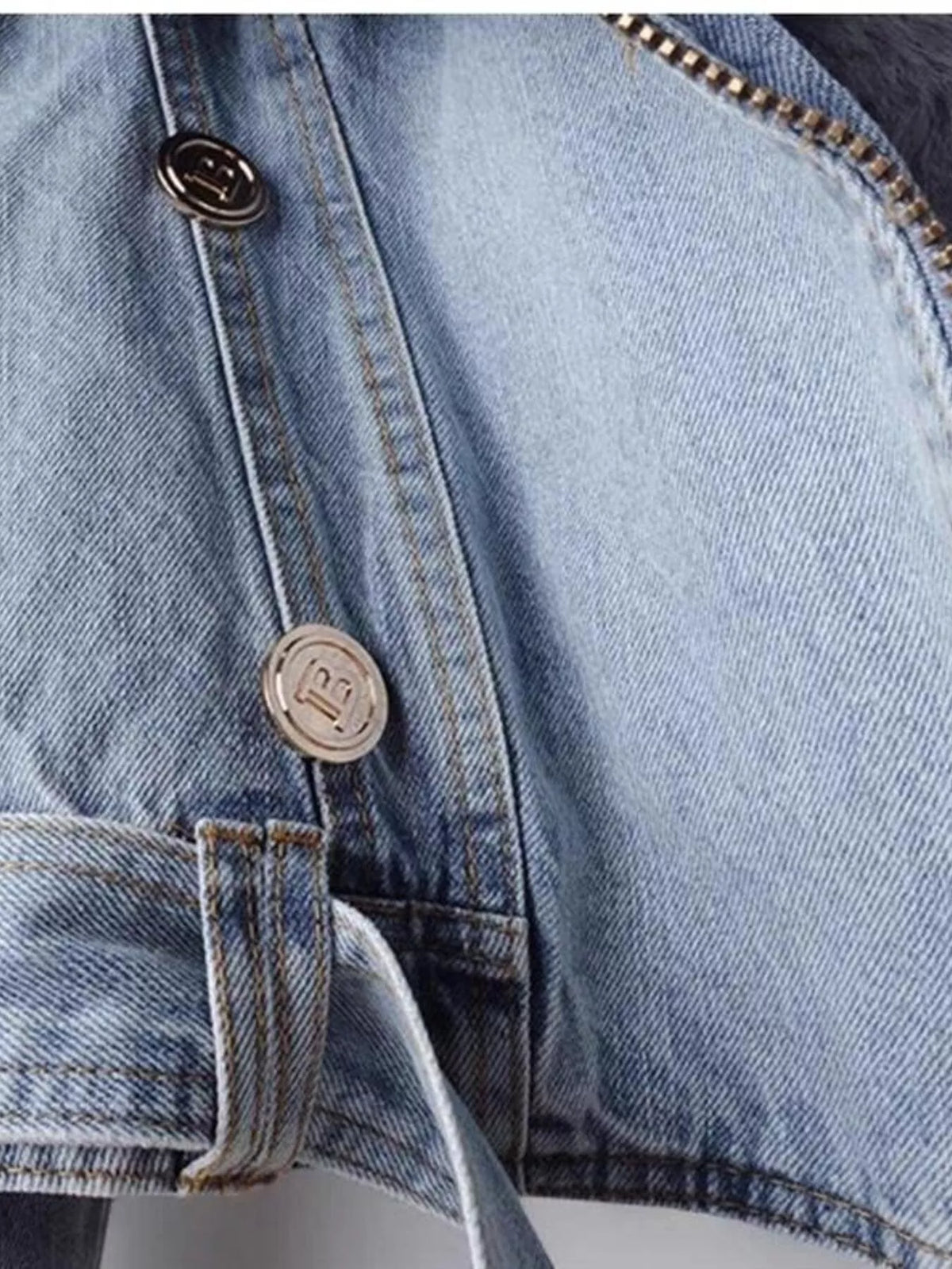 Primer plano de chaqueta vaquera azul claro con botones metálicos, costuras visibles y detalle del tejido denim lavado. NINA AURA COLLECTION.