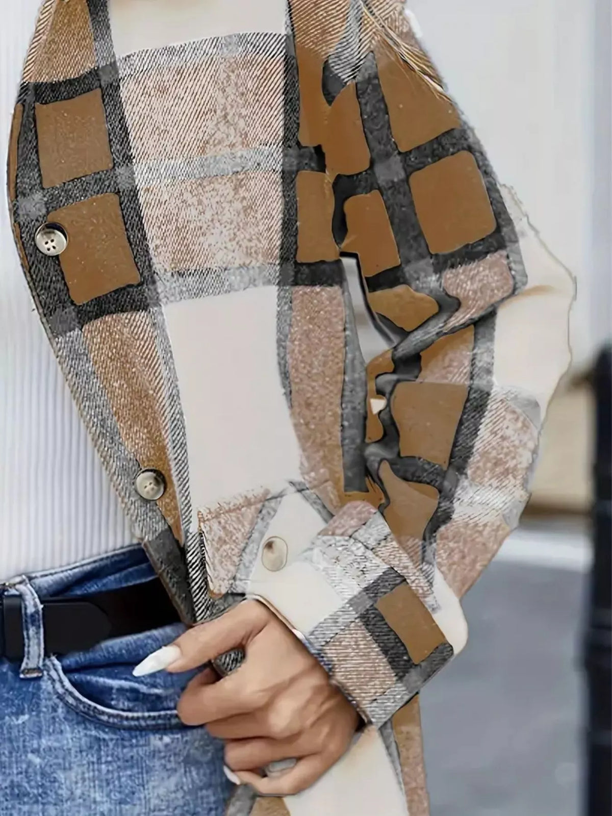 Primer plano de sobrecamisa de cuadros camel, beige, blanco y gris para mujer, con detalle del tejido, botones delanteros y puño abotonado.