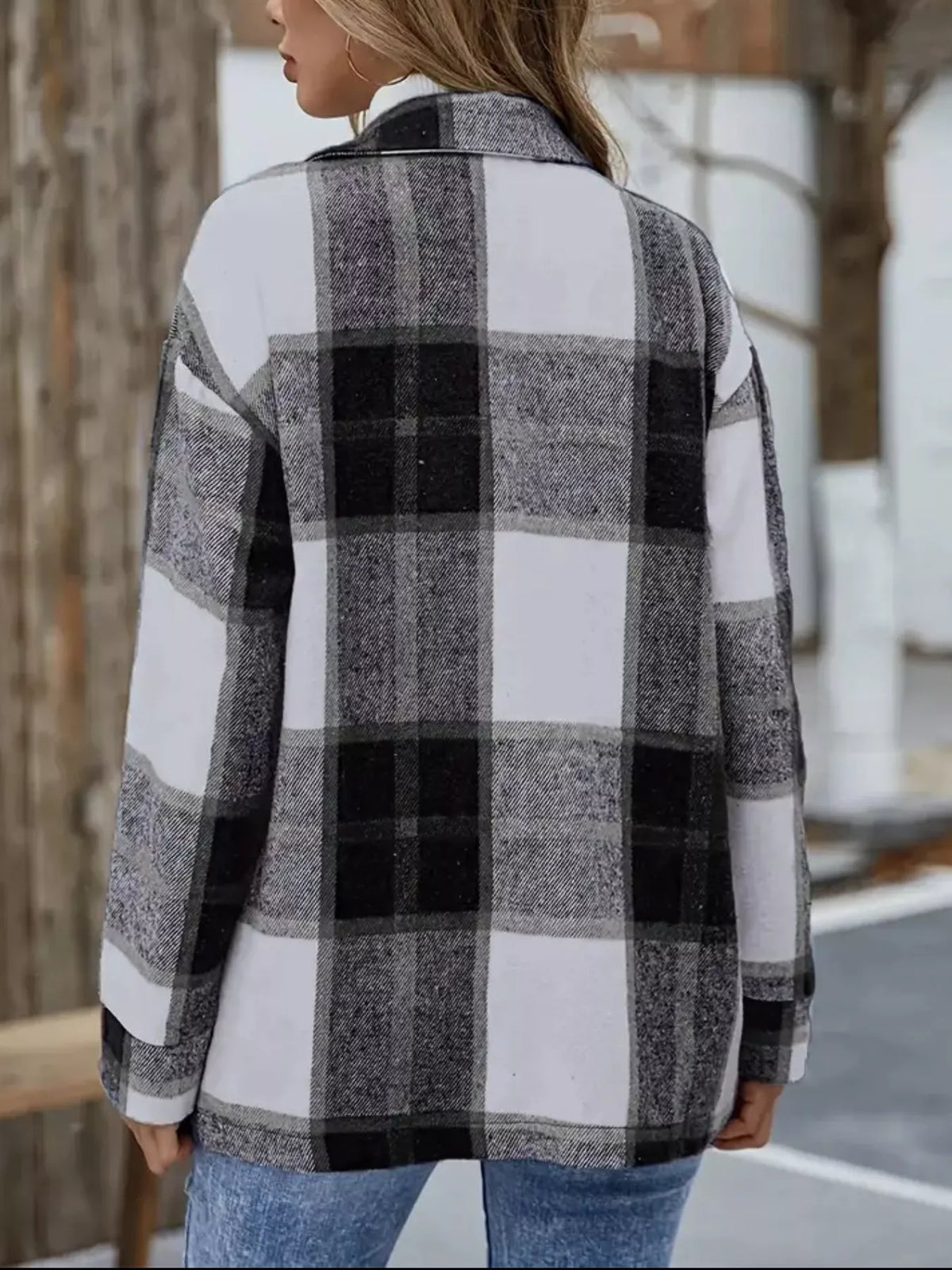 Vista trasera de sobrecamisa larga de mujer con estampado de cuadros negros, grises y blancos, mangas largas y bajo recto. NINA AURA COLLECTION.
