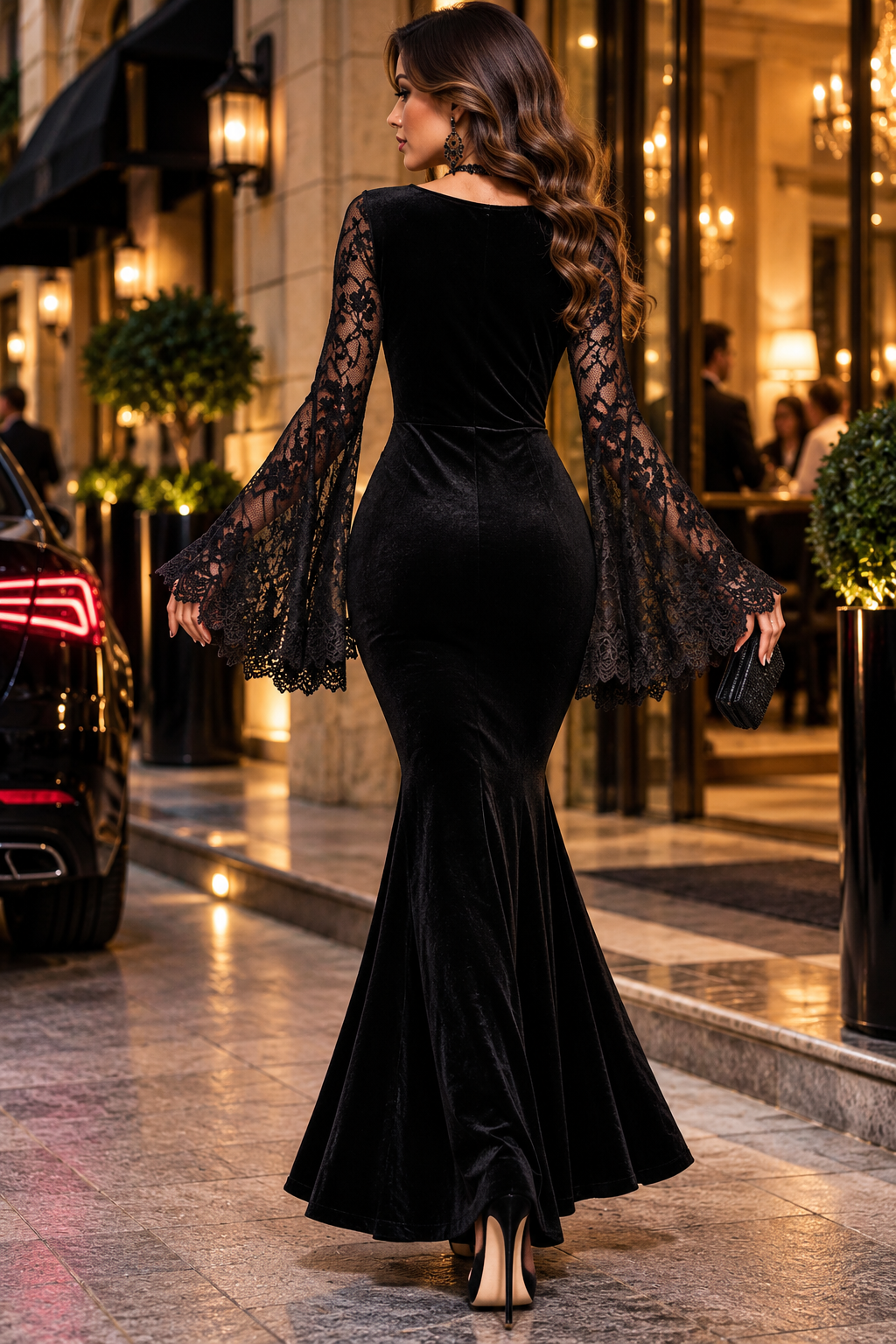 Vista trasera de vestido largo de terciopelo negro con espalda lisa, mangas de encaje floral negro y falda de corte sirena.
